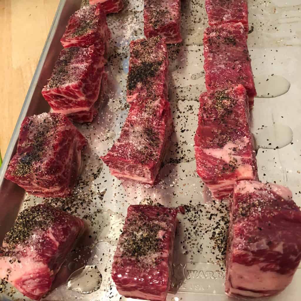 Short ribs on a sheet pan, being seasoned for Galbi Jim.