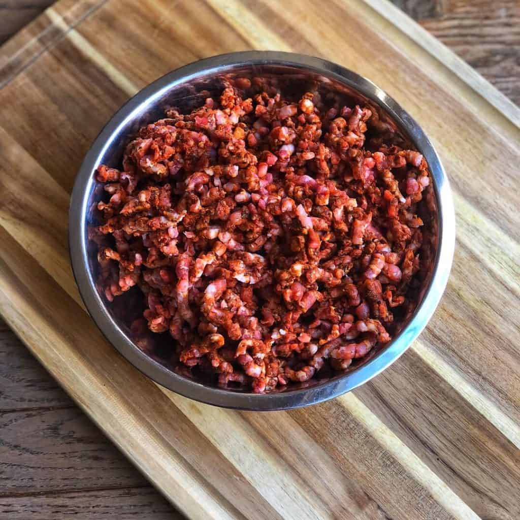 A metal bowl filled with a fully mixed chorizo meat mixture.