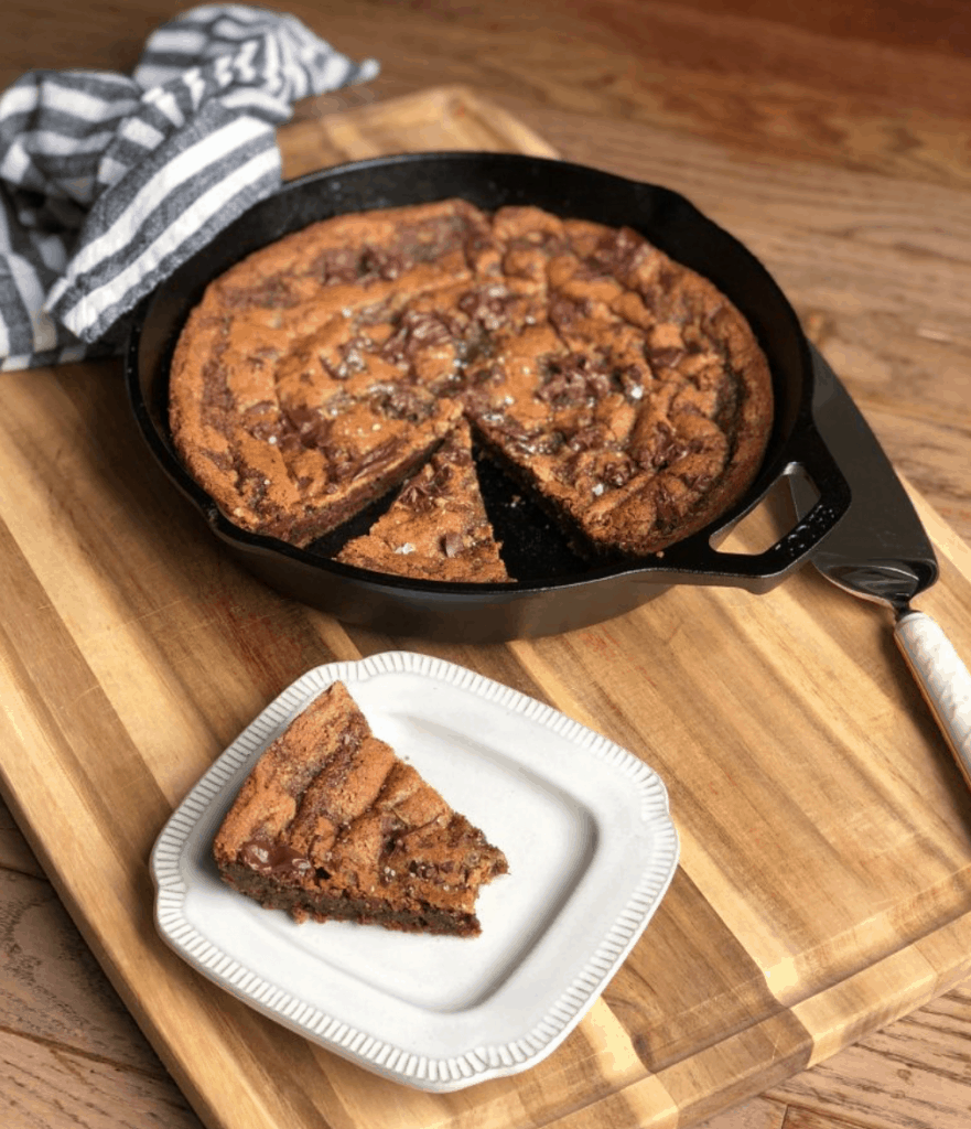 Cast Iron Skillet Chocolate Chip Cookie Cake with a slice on a small white square plate