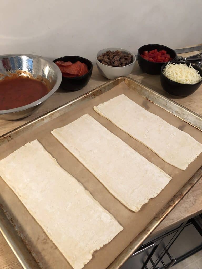 Three rectangles of puff pastry on a parchment lined baking sheet.