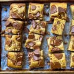 A sheet pan with Peanut Butter Blondies, embedded with Reese's peanut butter cups.
