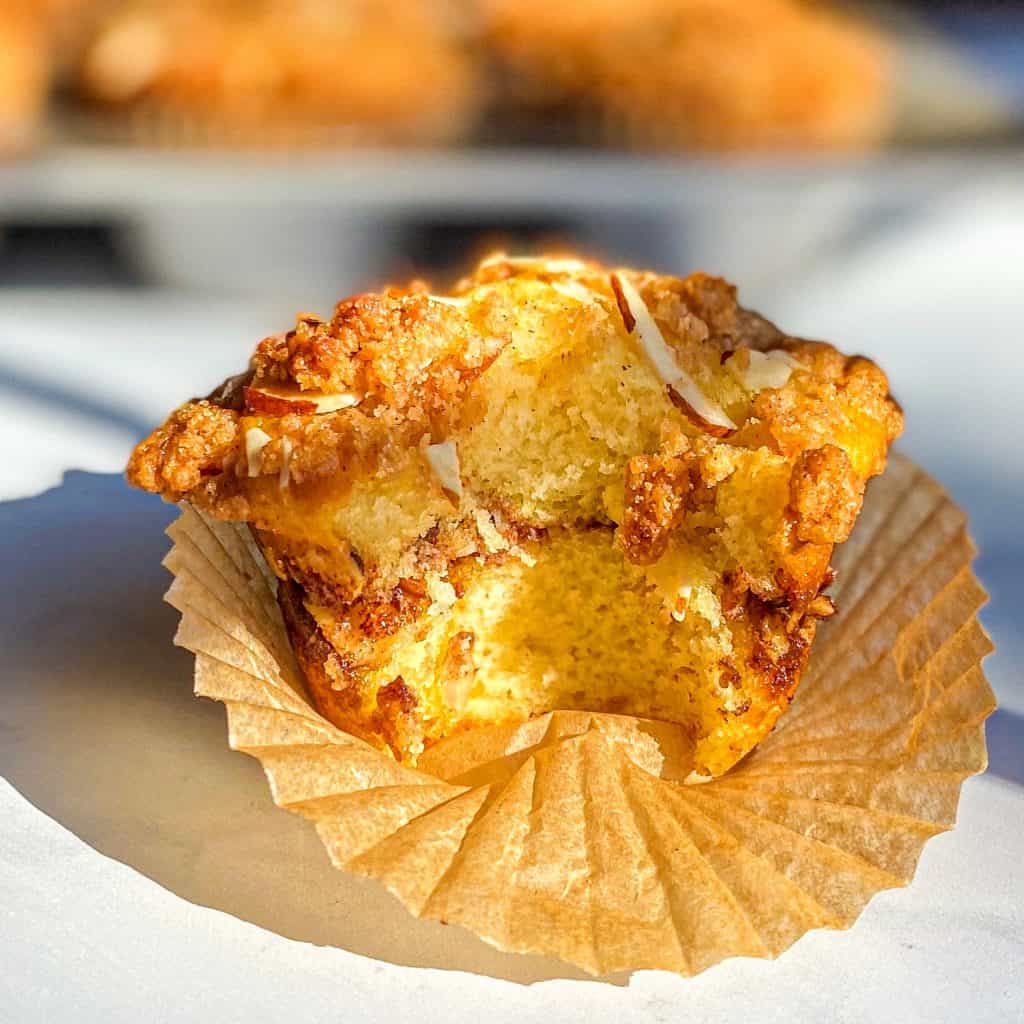 Cupcake liner opened to reveal Cinnamon Swirl Streusel Muffin with a bite taken out