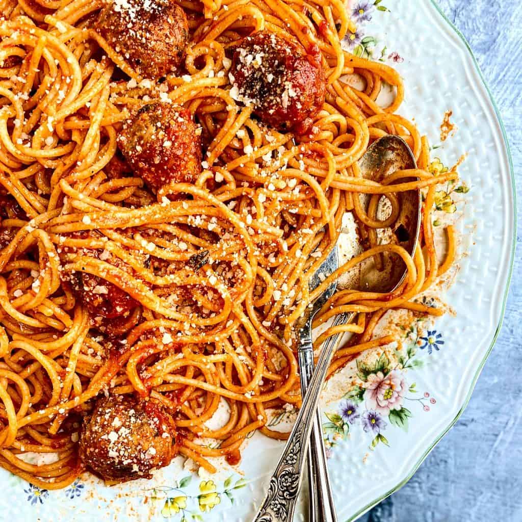 A flowered plate with Spaghetti and meatballs with marinara