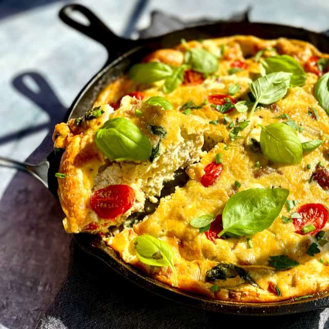 Slicing into Italian Frittata, baked in a cast iron pan