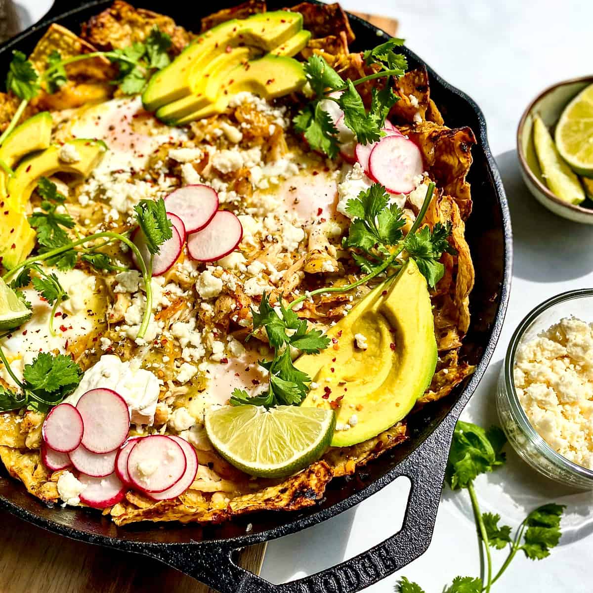 Chicken Chilaquiles Verde with Baked Eggs in a cast iron pan