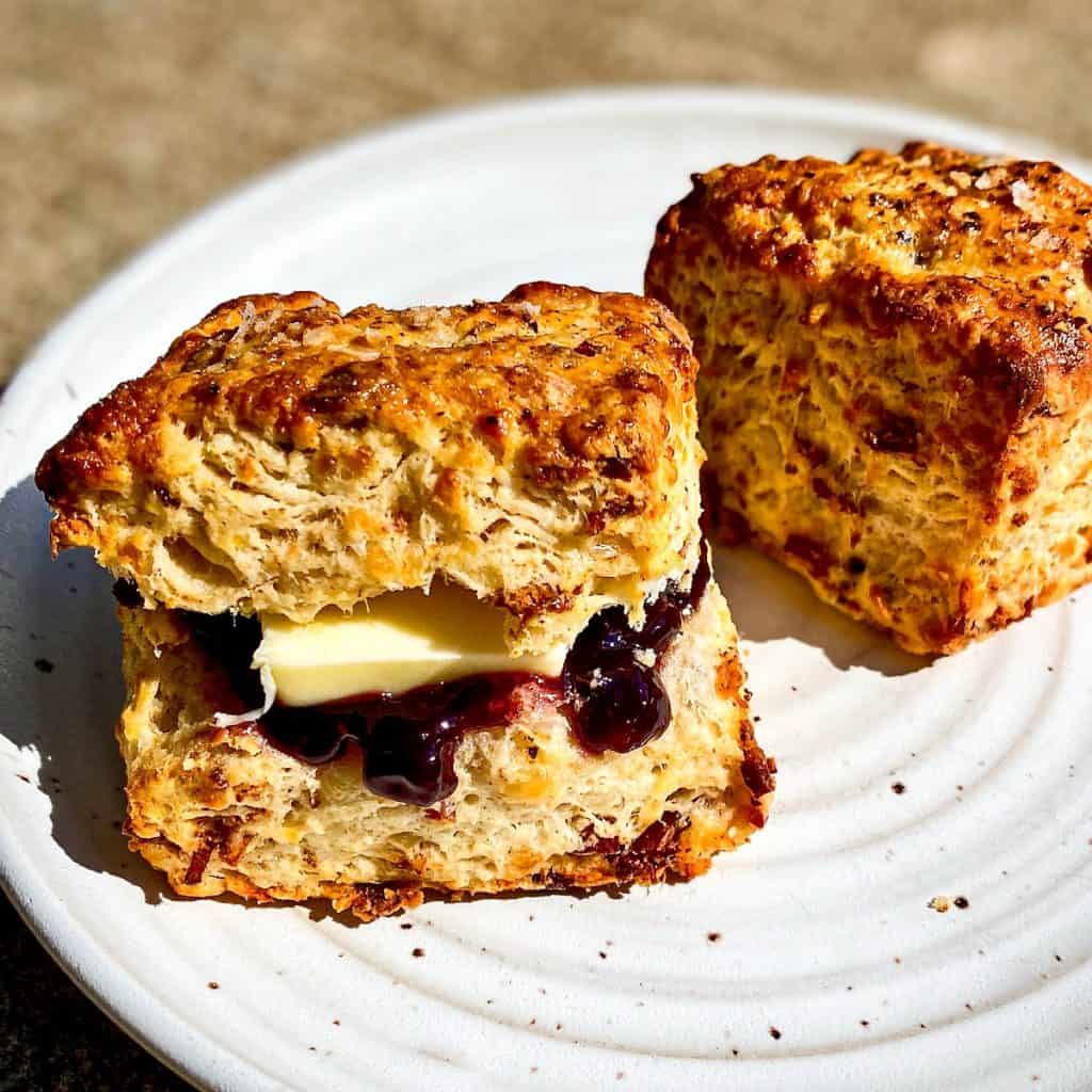 Bacon and Gruyere Biscuits, one of which has blueberry jam and butter.