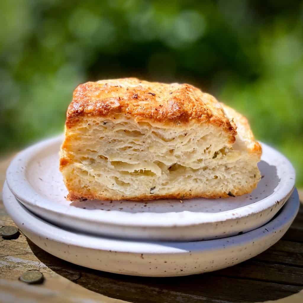 One Flaky Buttermilk Biscuit on a stack of white plates