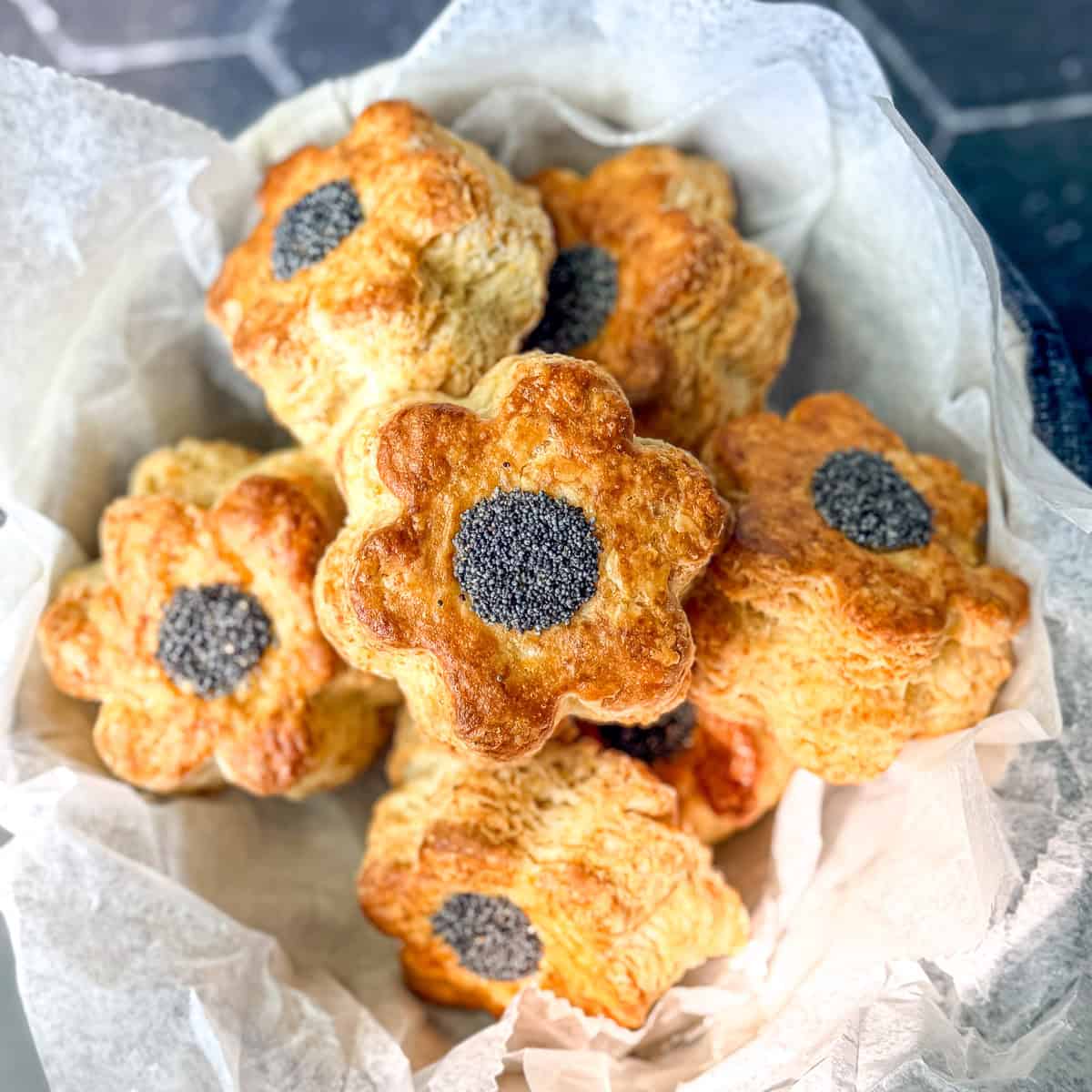 flower biscuits with poppy seed centers in a basket.