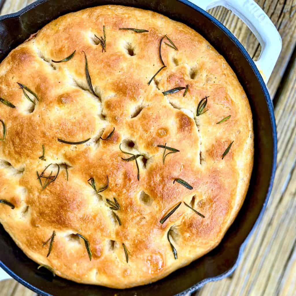 White cast iron pan containing No-Knead Rosemary-Garlic Focaccia Bread