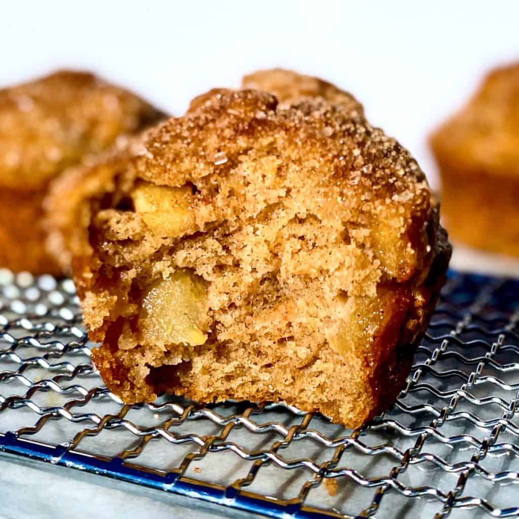An apple cinnamon crunch muffin on a baking rack.