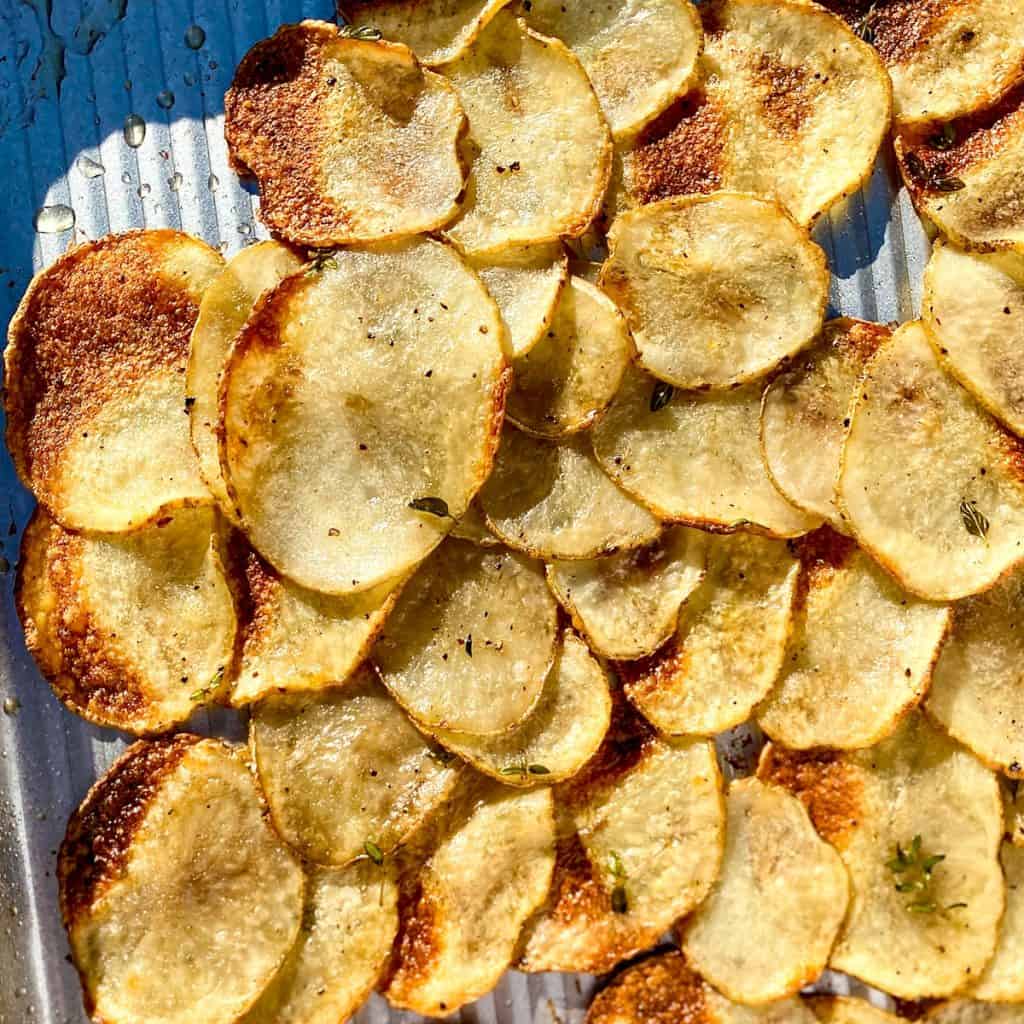 A sheet pan with very thinly sliced baked potatoes
