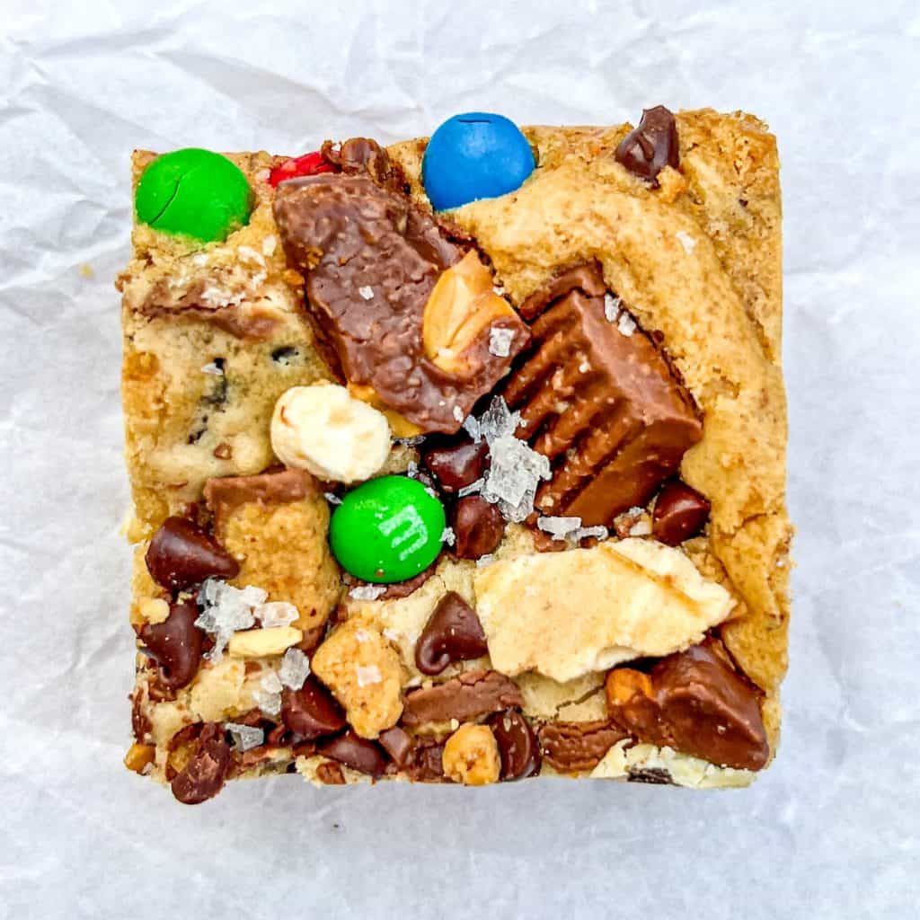 A single halloween candy blondie on a piece of crumpled parchment paper.