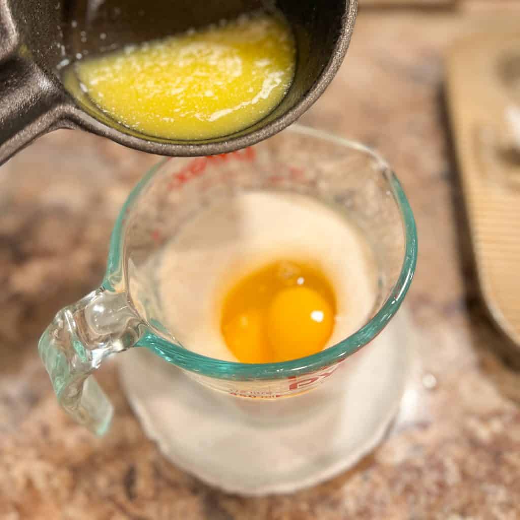 Adding butter to other wet ingredients for making muffins.