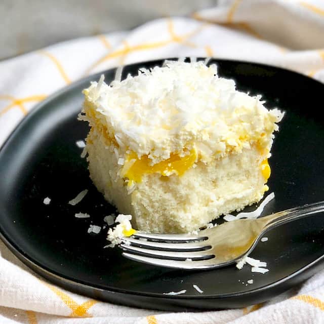 Coconut cloud cake with lemon curd on a black plate/
