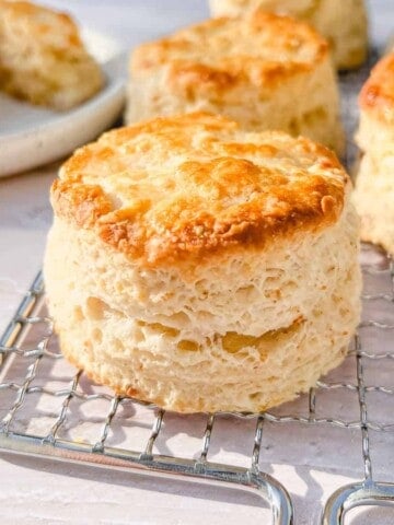 Flaky buttermilk biscuits on a wire rack.