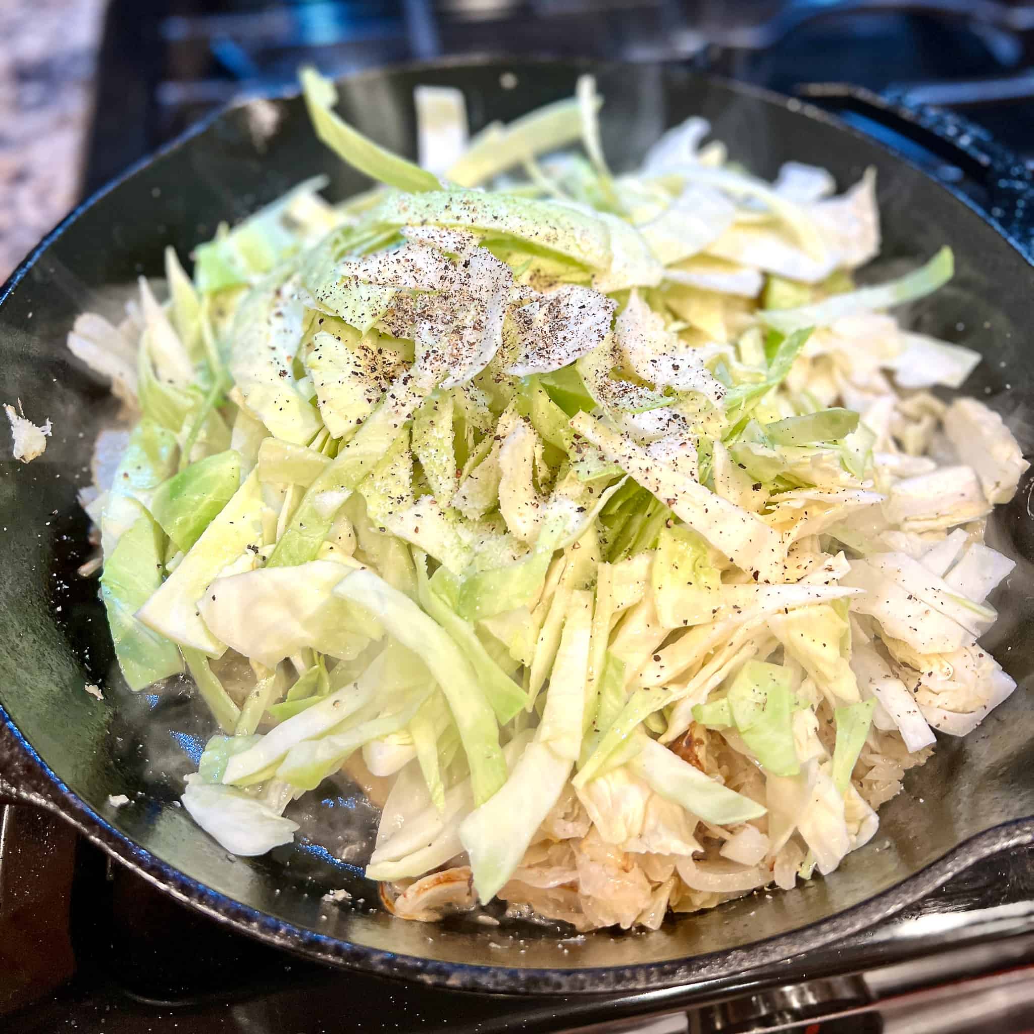 Sauteeing cabbage in a cast iron pan.