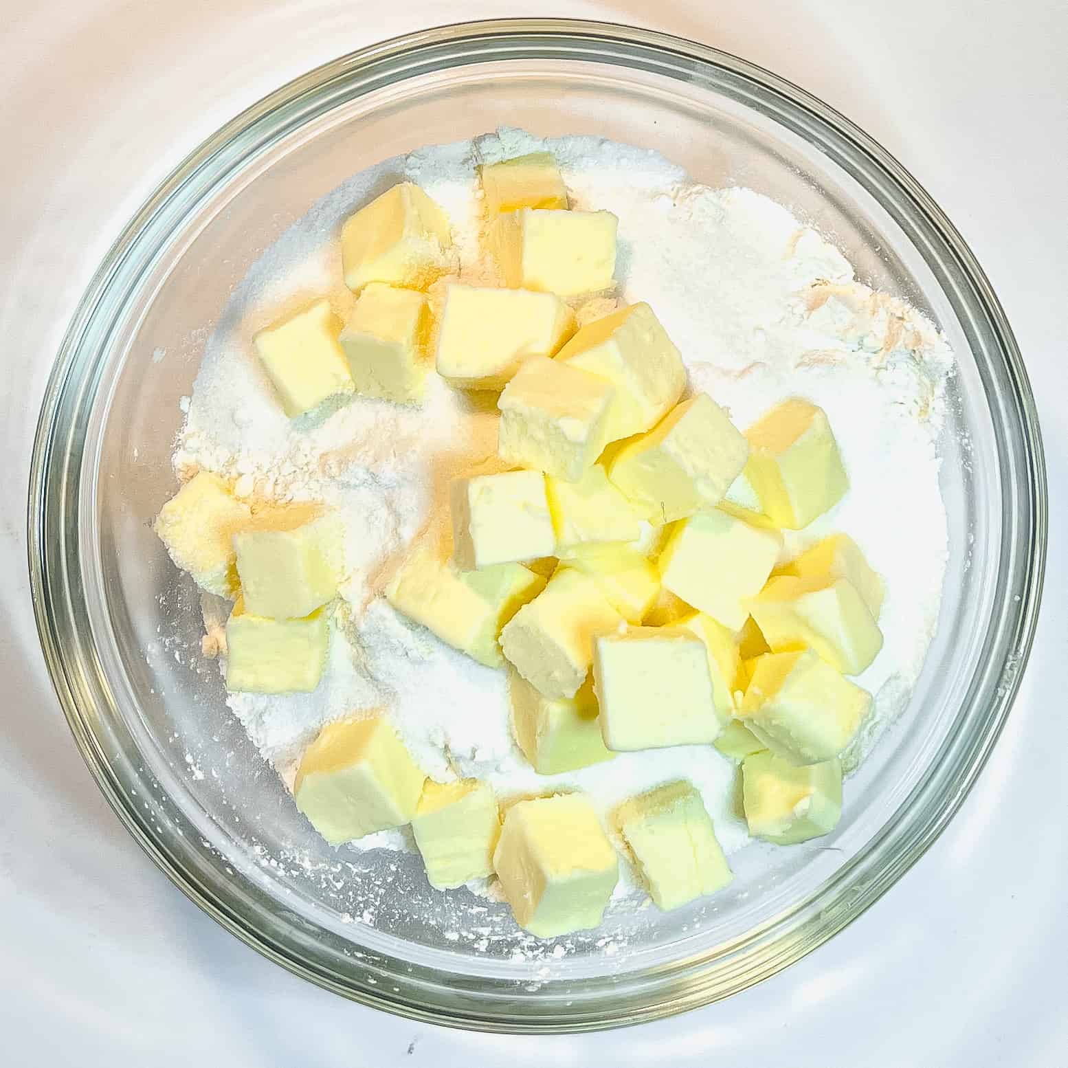 Dry ingredients and chunks of butter in a glass bowl.