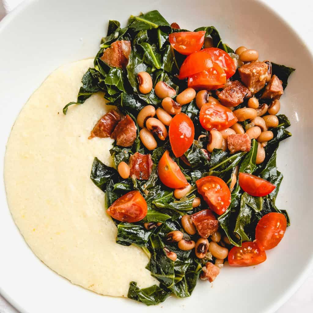 Cheesy Grits with Collard Greens & Black Eyed Peas in a white bowl.