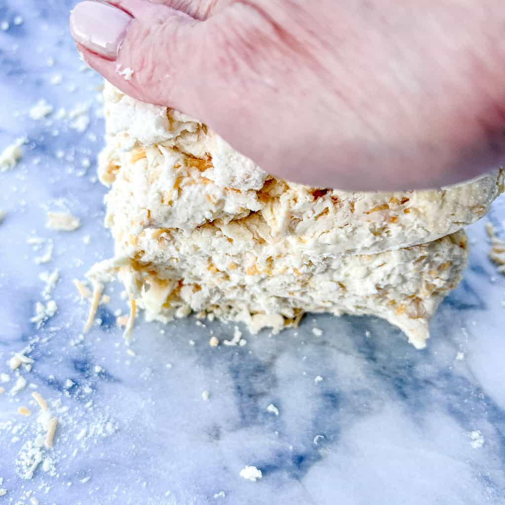 Pressing down on biscuit dough.