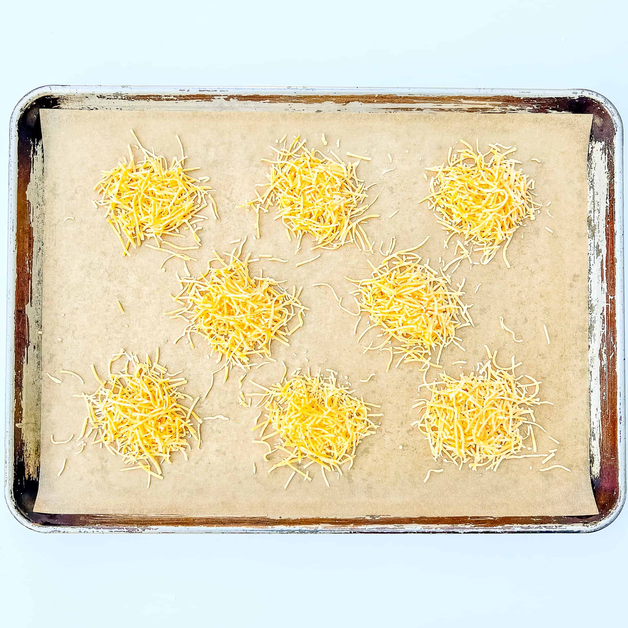 Piles of cheddar on a sheet tray.