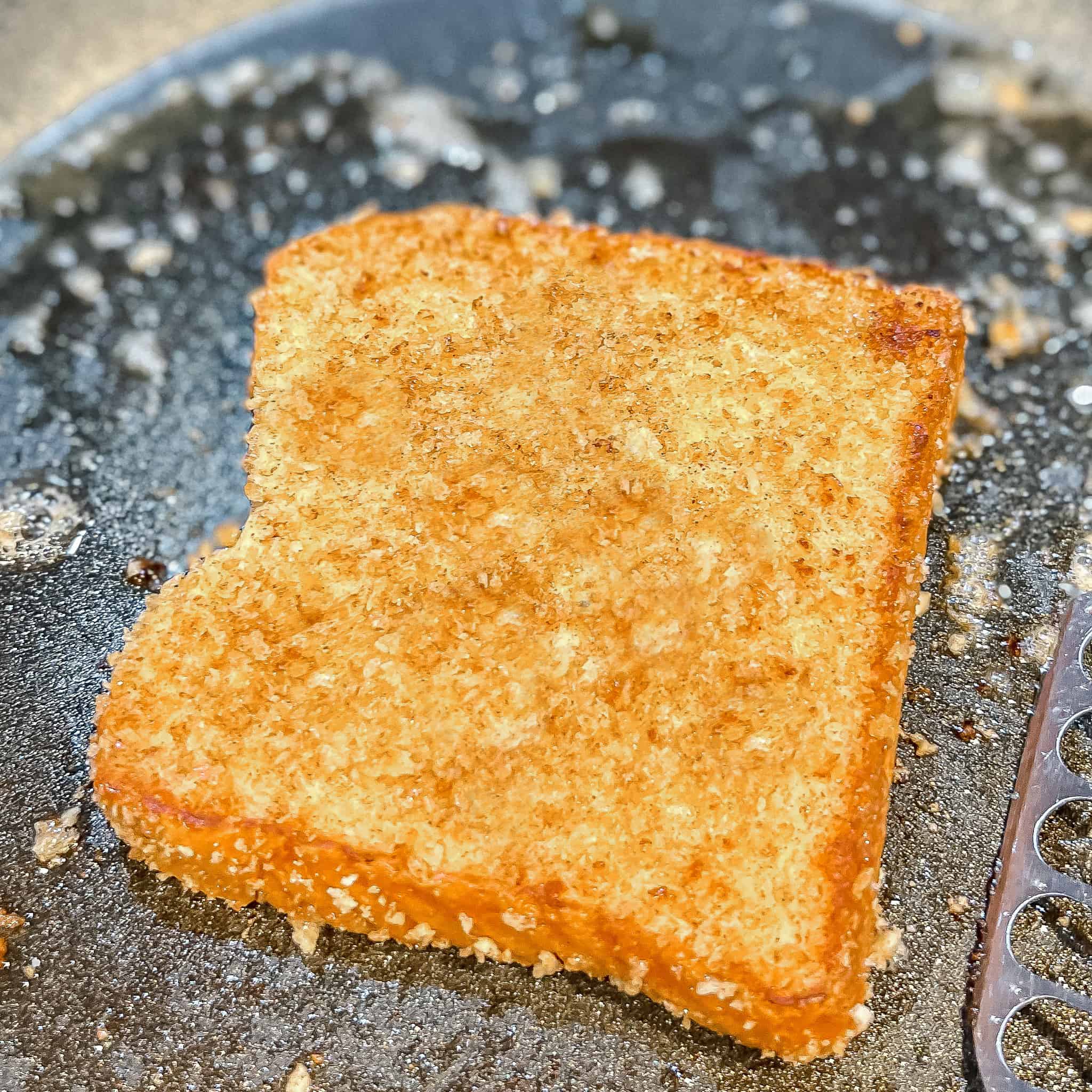 Flipping cinnamon toast crunch french toast in pan.