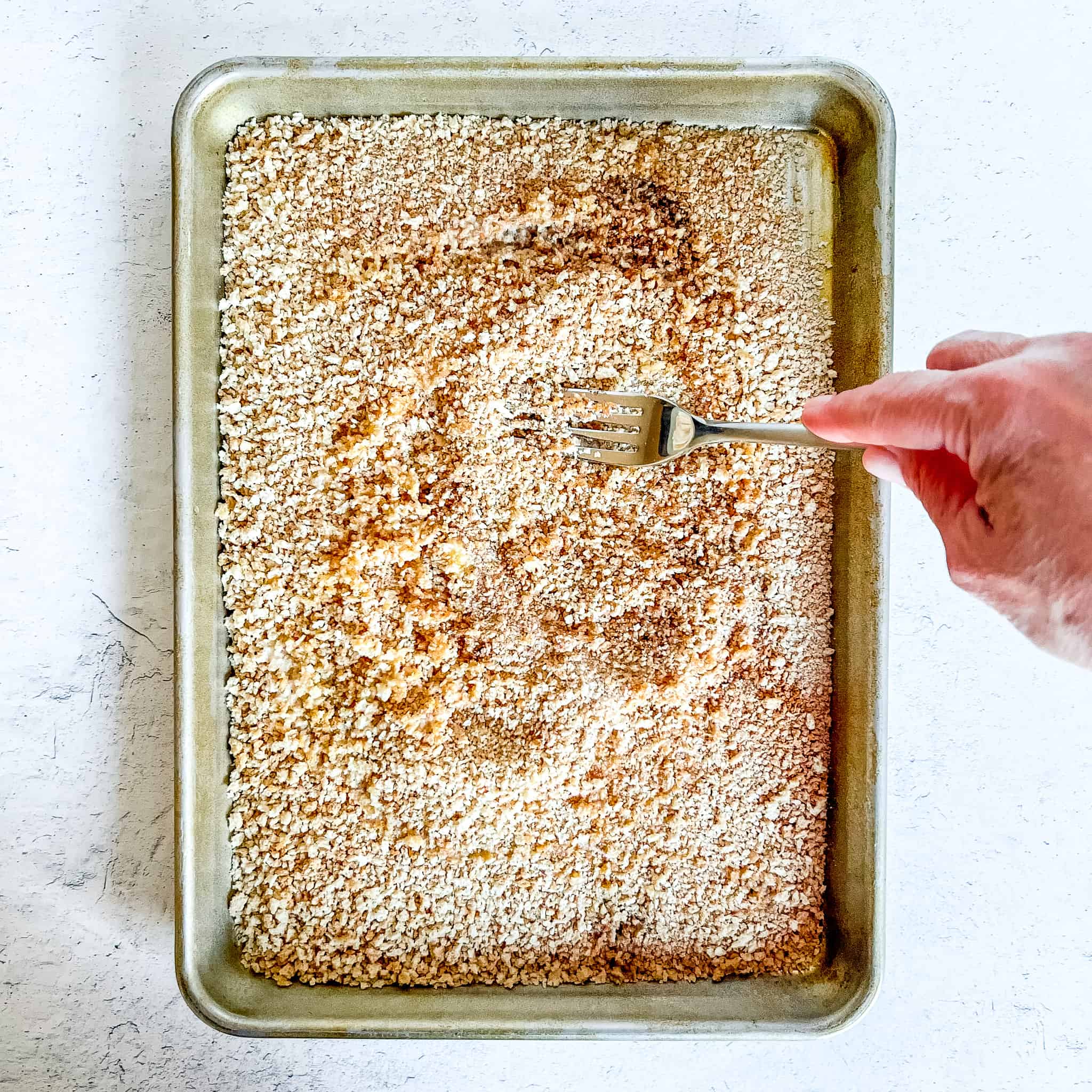 Mixing melted butter into cinnamon panko crumbs.