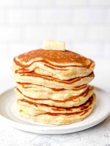 Stack of pancakes with butter on top.