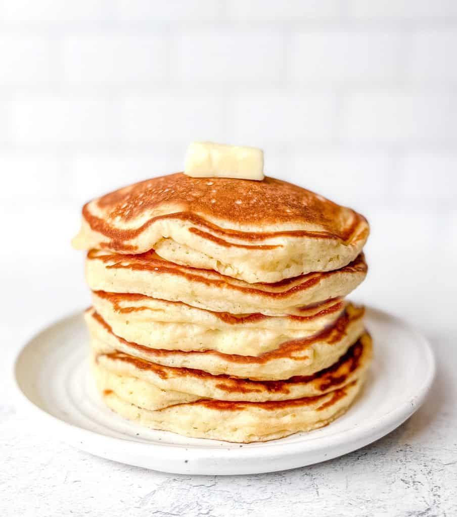 Stack of pancakes with butter on top.