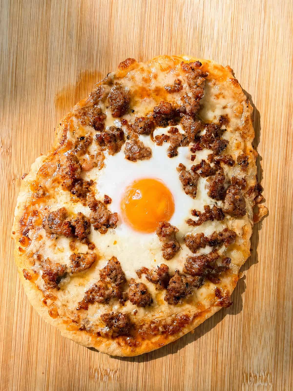 Flatbread pizza on a wooden cutting board.