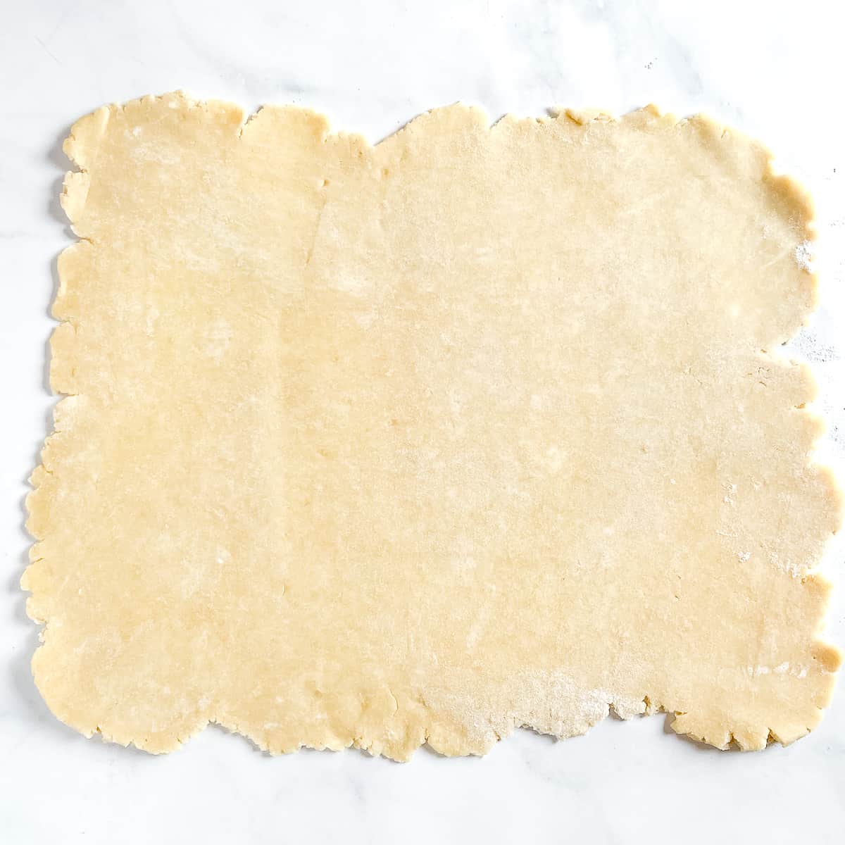 pie dough rolled out into large rectangle.