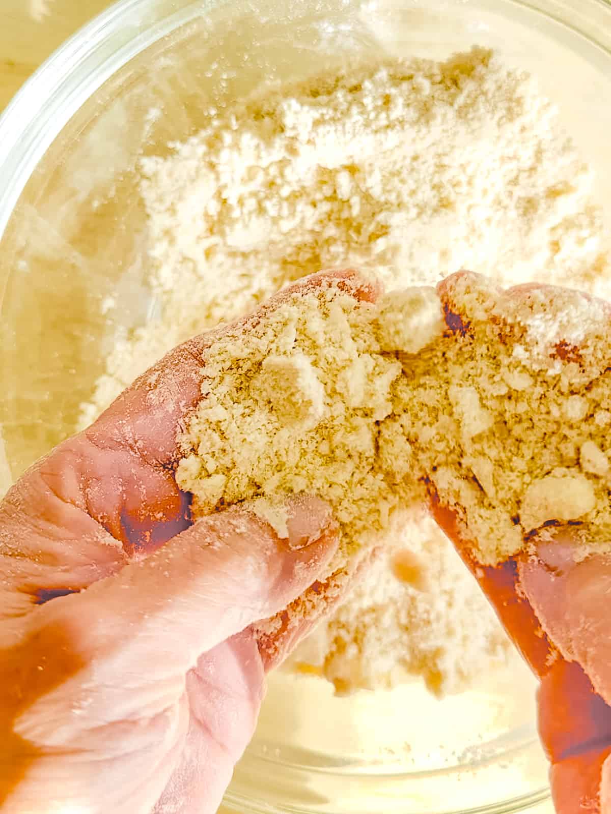 Fingers showing butter incorporated into biscuit dry ingredients.