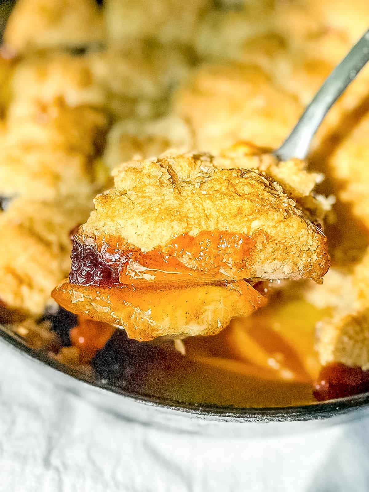 Serving up a portion of blackberry peach cobbler.