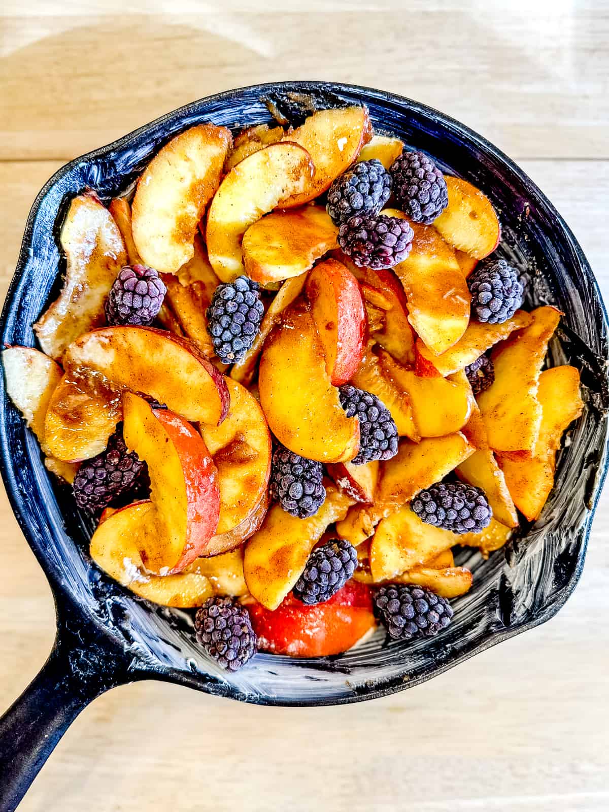 Blackberry peach cobbler in a cast iron pan before adding biscuit topping.