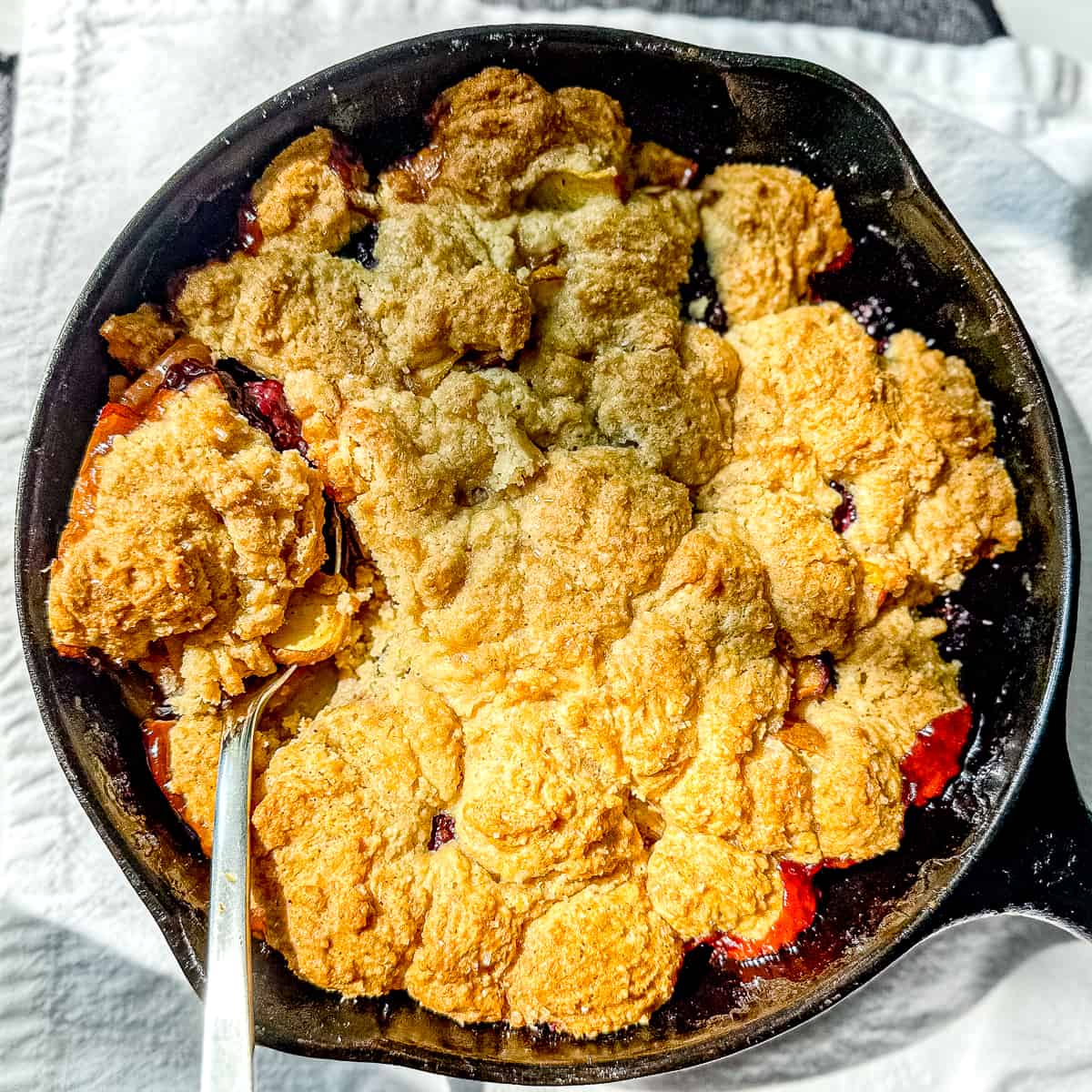 Blackberry peach cobbler in a cast iron pan.