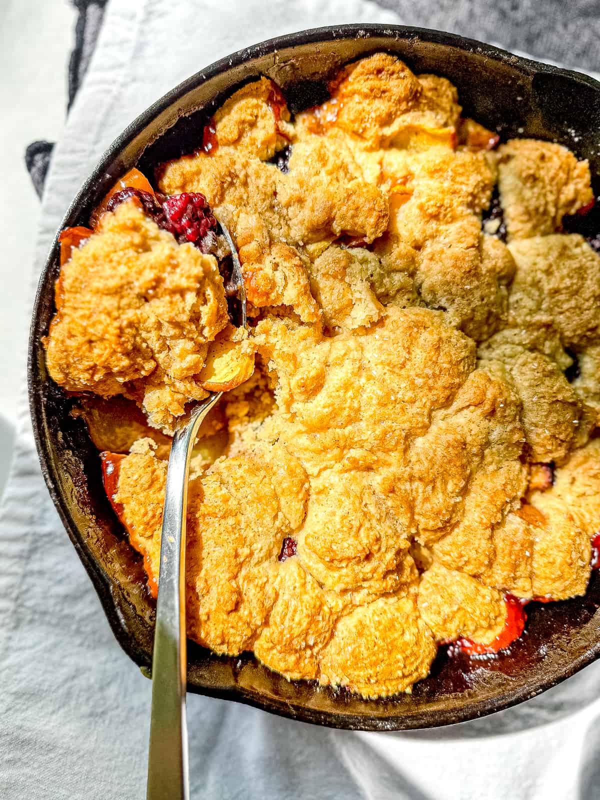 Blackberry peach cobbler in a cast iron pan.