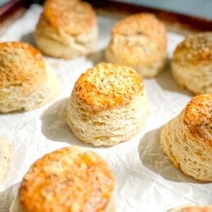 45 degree angle of cacio e pepe biscuits on a parchment lined sheet pan.