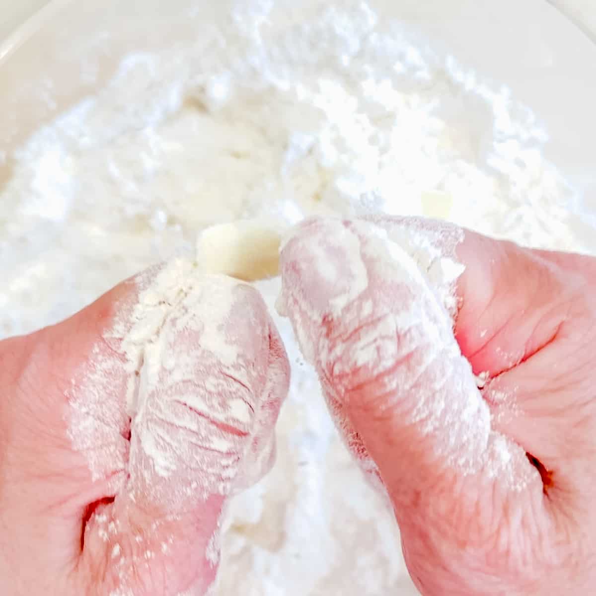 Mashing butter into flour for making biscuits.