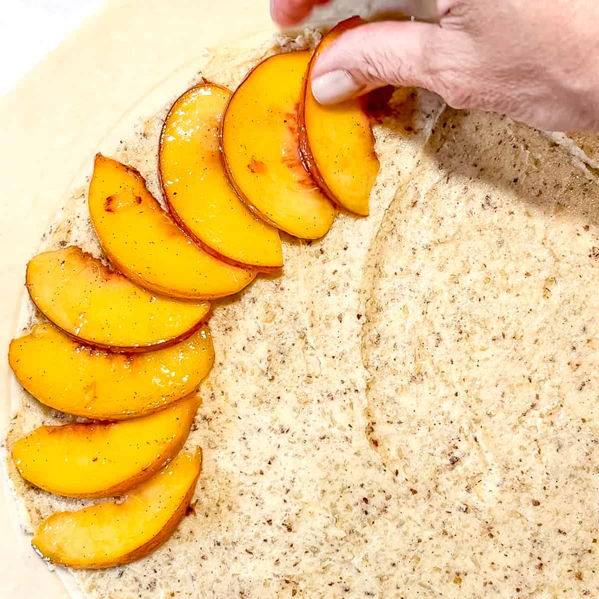 Placing peaches over frangipane.