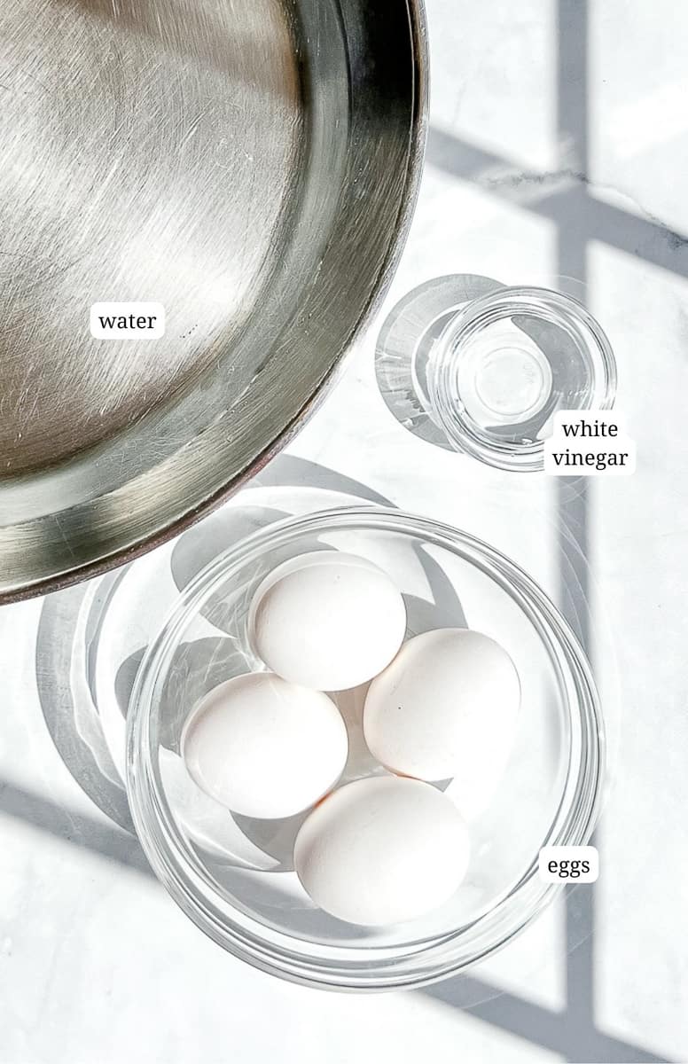 a skillet of water, a bowl of white vinegar, and four eggs.