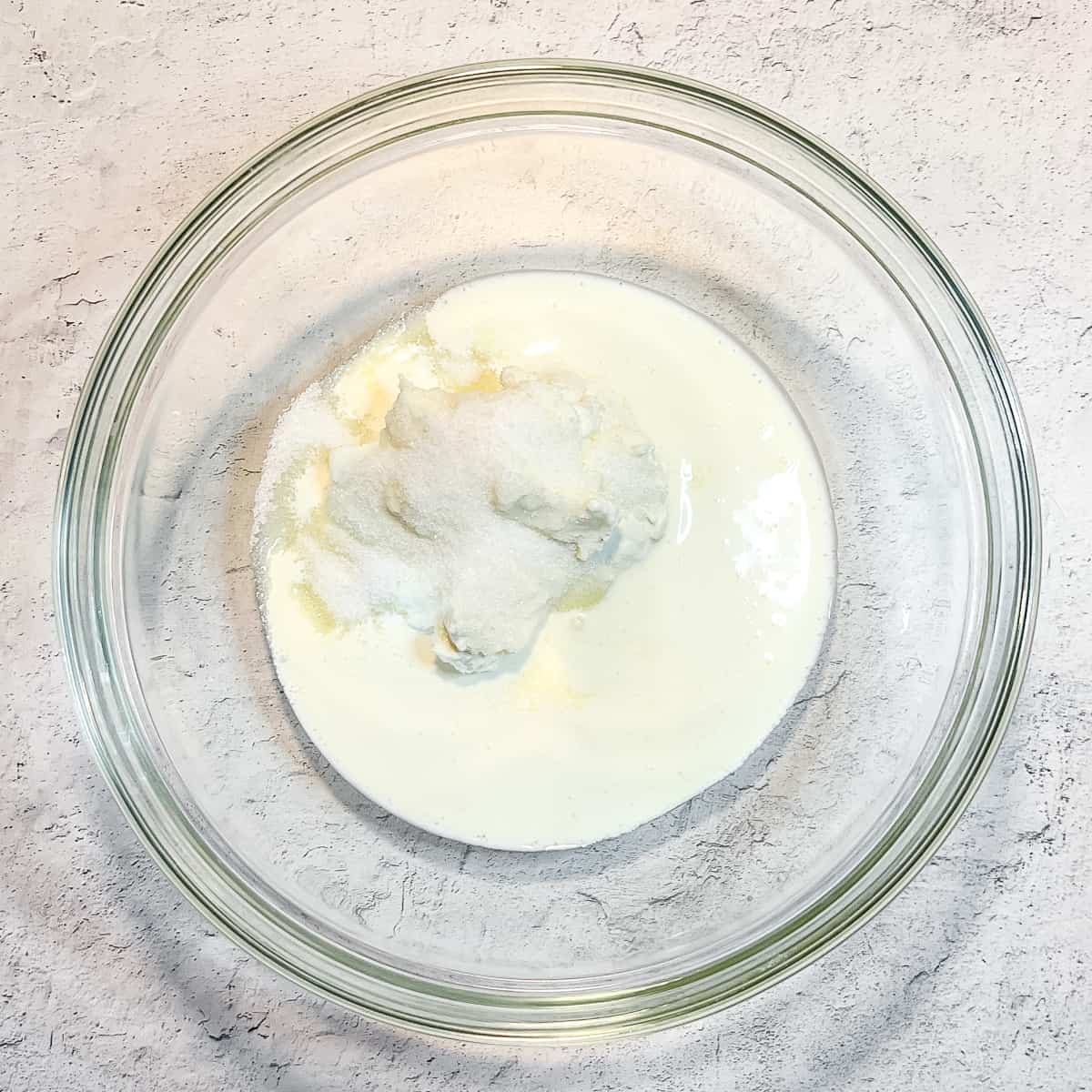 heavy cream, greek yogurt, and sugar in a glass bowl.