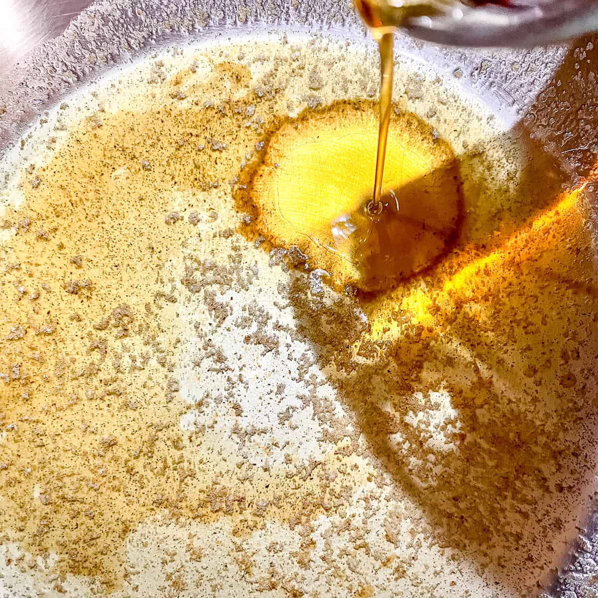adding maple syrup to brown butter in skillet.