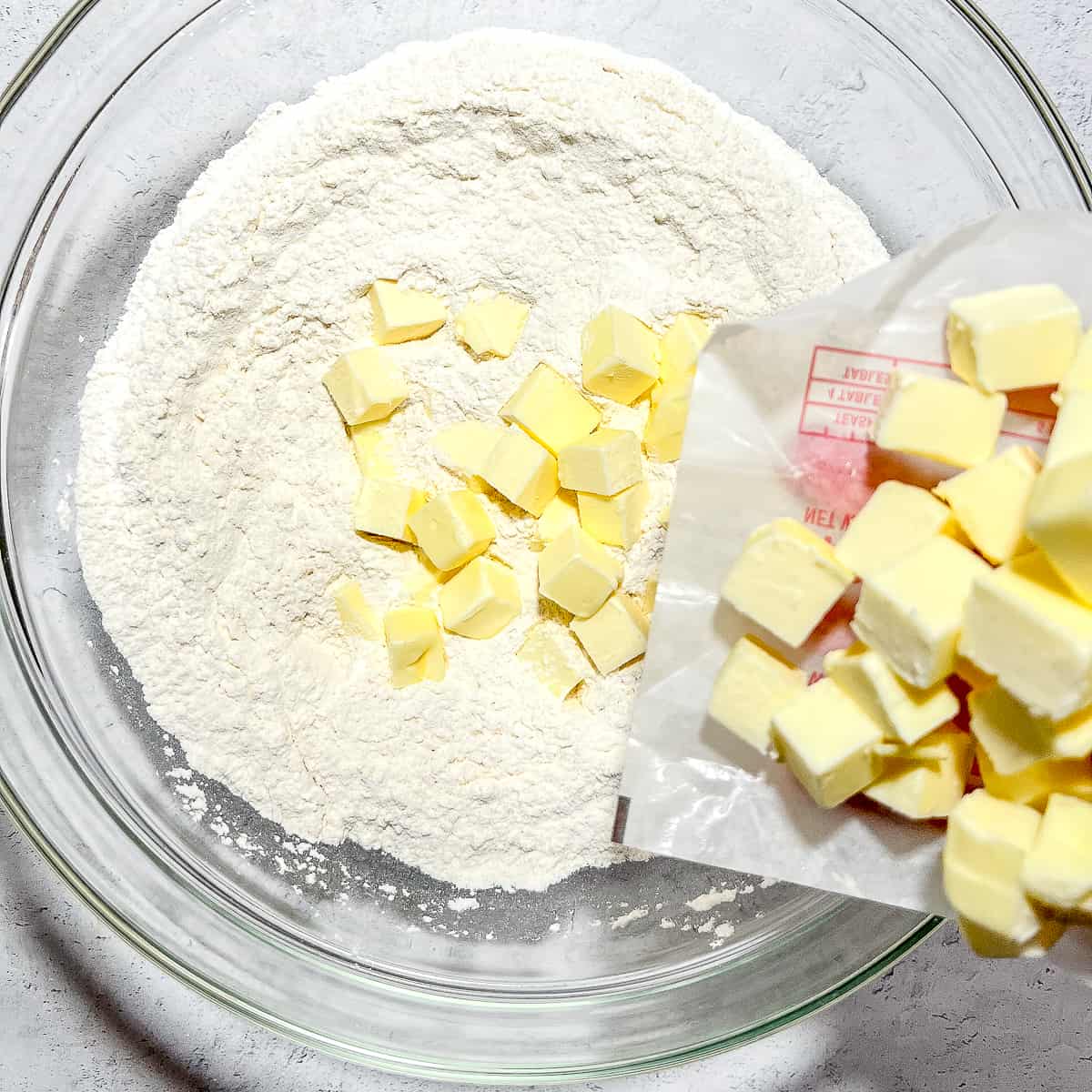 adding butter to dry ingredients for biscuits.