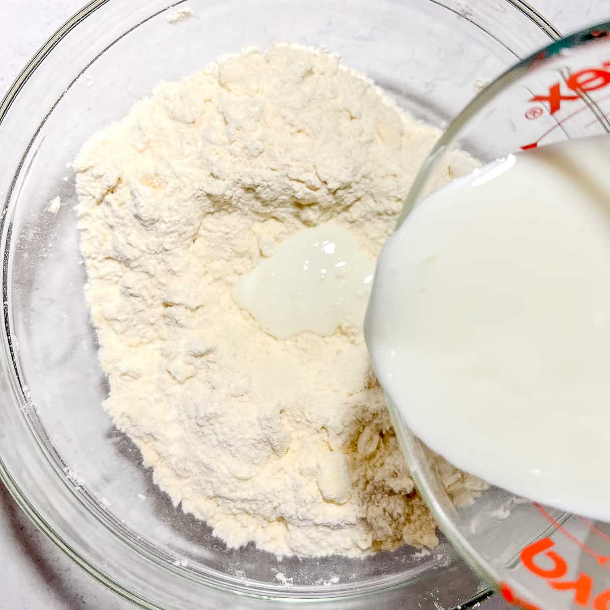 pouring buttermilk into butter and flour mixture.