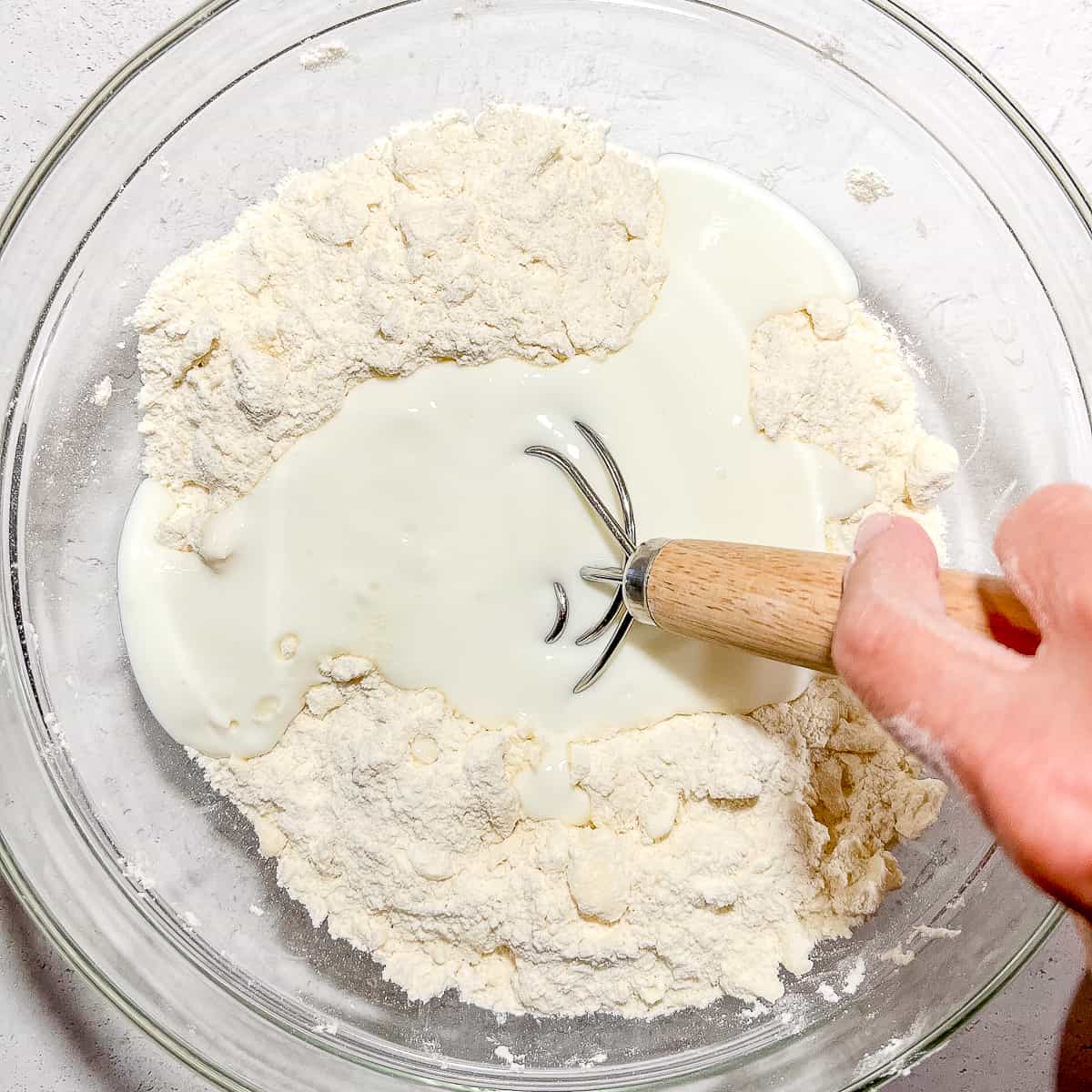 mixing butter into flour and butter mixture for biscuits.