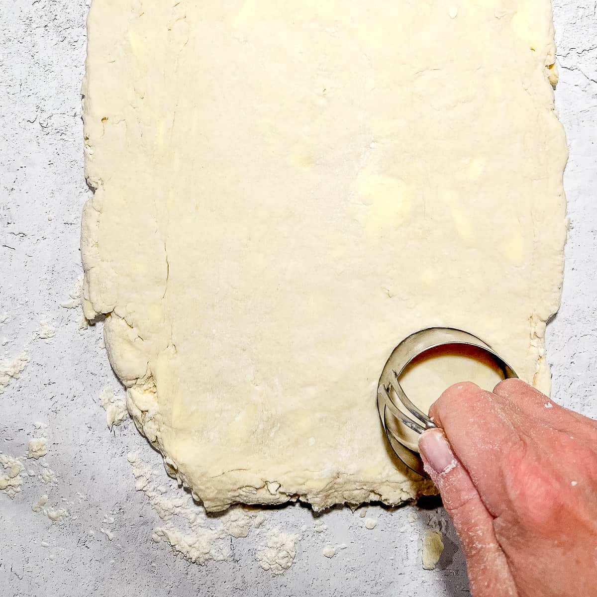 cutting out biscuits from large piece of dough.