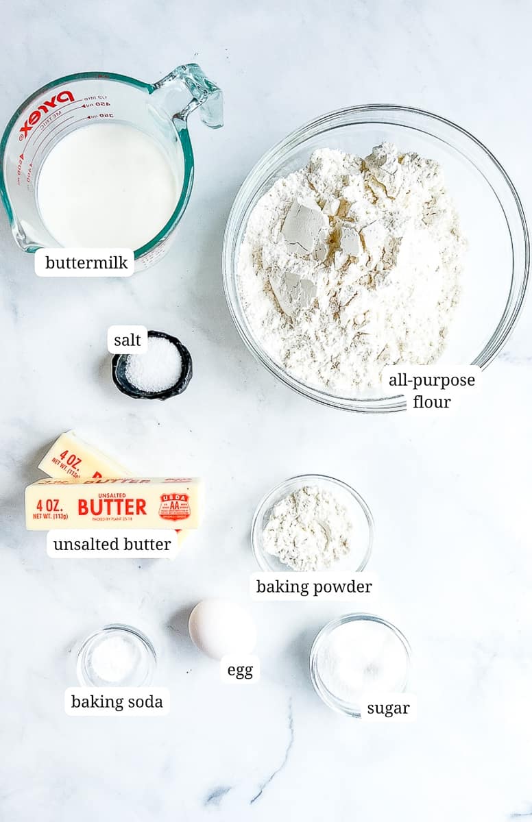 ingredients for buttermilk biscuits on a marble background.