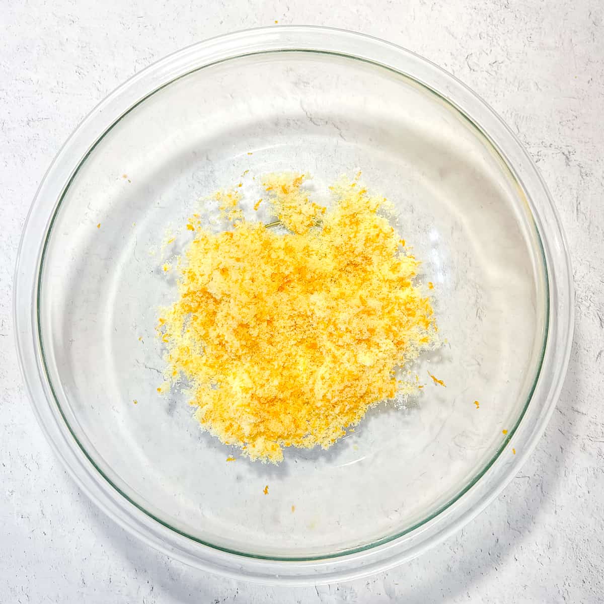orange zest and sugar in a glass bowl.