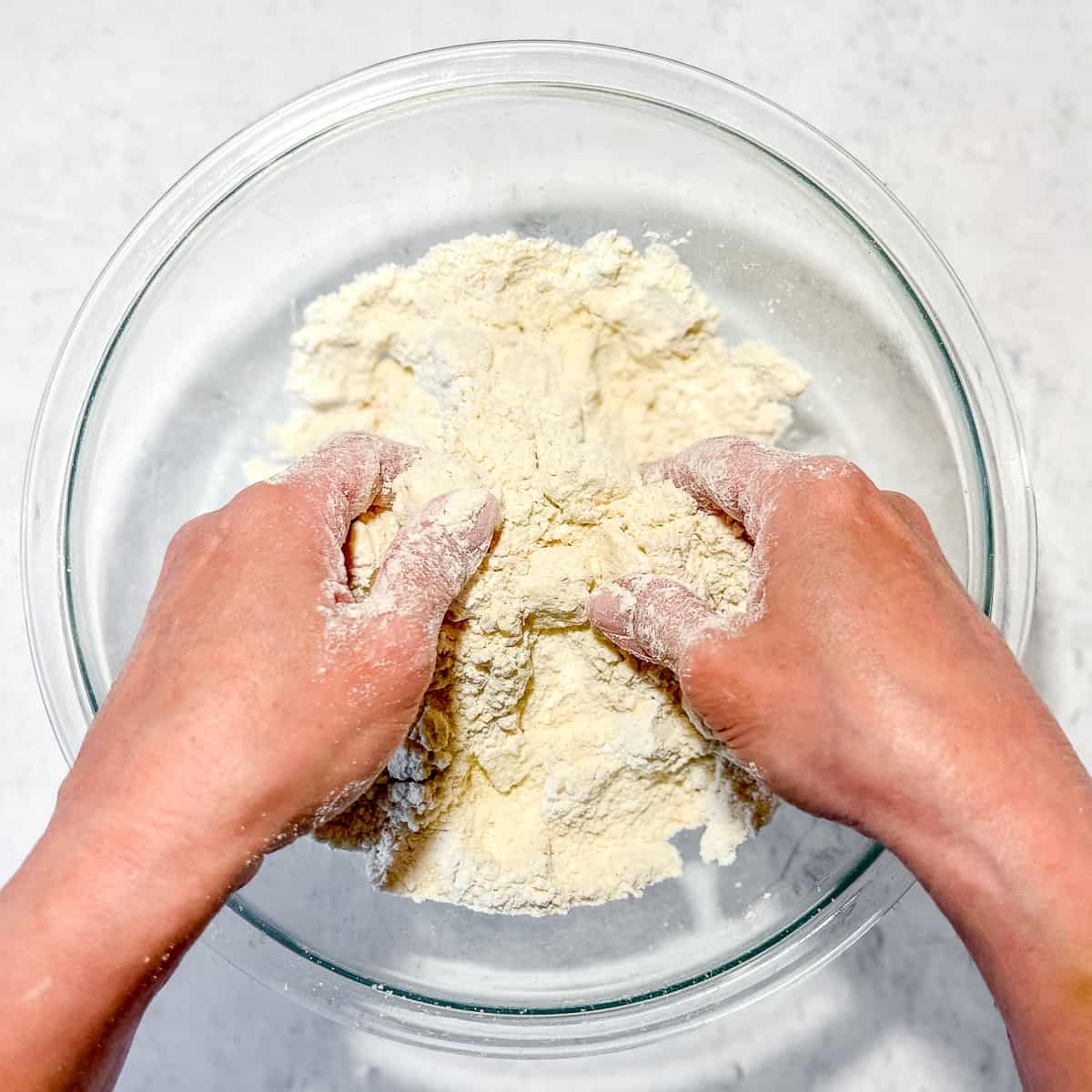 using fingers to cut butter into dry ingredients.