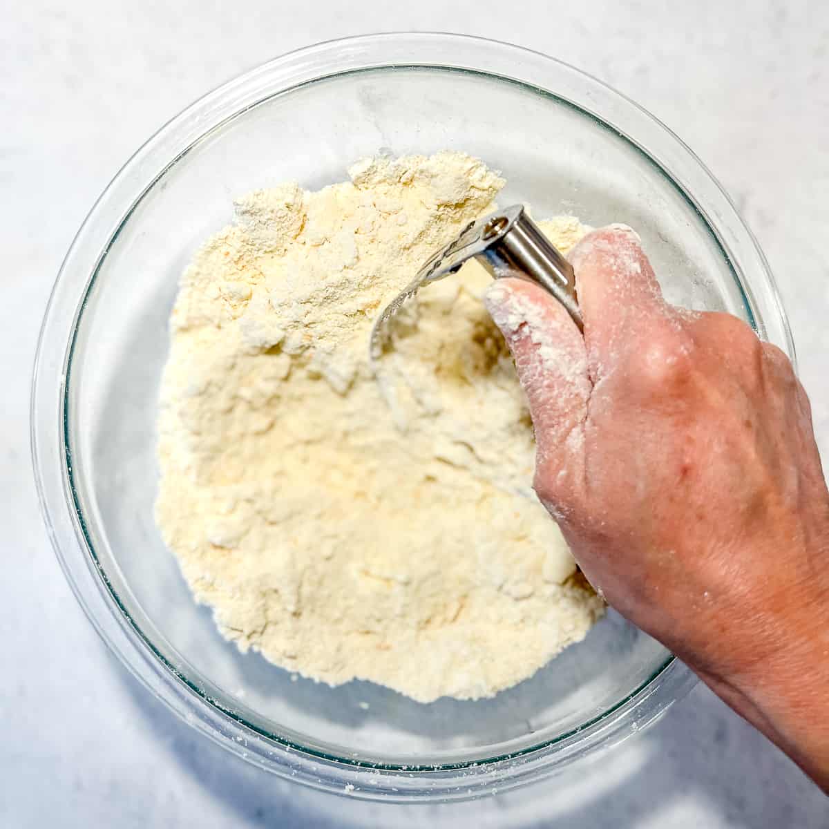 using pastry cutter to mix butter into dry ingredients.