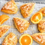 Glazed orange scones on a wire rack with orange slices